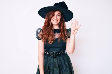 Cadılar Bayramı kostümü giymiş genç ve güzel bir kadın gülümseyerek kendinden emin ve mutlu bir şekilde dört numarayı işaret ediyor.. 