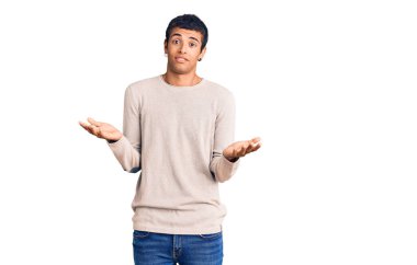 Sıradan kıyafetler giyen, kafası karışmış, elleri ve kolları havada genç bir Afrikalı Amerikalı. şüphe kavramı. 