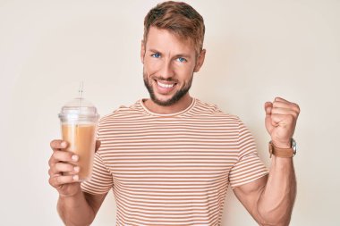 Kafkasyalı genç adam bir bardak portakal suyu içiyor gururla bağırıyor, zaferi kutluyor ve başarıyı kollarını kaldırarak kutluyor. 
