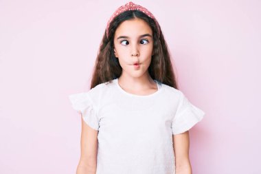 Günlük kıyafetler giyen tatlı İspanyol kız çocuğu ve diyadem dudaklı balık suratı yapıyor, çılgınca ve komik bir jest. Komik ifade. 