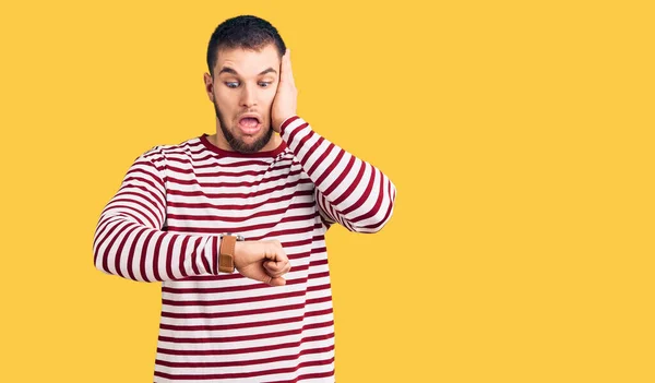 Young Handsome Man Wearing Striped Sweater Looking Watch Time Worried — Stock Photo, Image