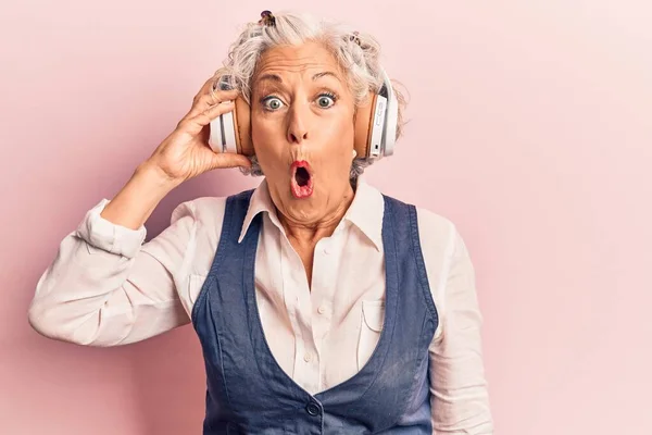 Starsza Siwowłosa Kobieta Słuchająca Muzyki Przy Użyciu Słuchawek Przerażona Zdumiona — Zdjęcie stockowe