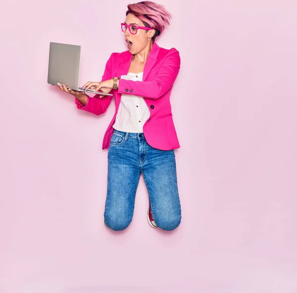 Młoda Piękna Bizneswoman Różowymi Krótkimi Włosami Okularach Uśmiechnięta Szczęśliwa Skoki — Zdjęcie stockowe