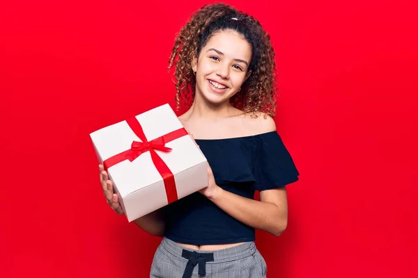 Beautiful Kid Girl Curly Hair Holding Gift Looking Positive Happy — Stock Photo, Image
