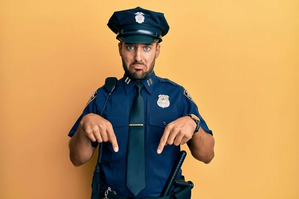 Bonito Hispânico Vestindo Uniforme Policial Apontando Para Baixo Olhando Triste — Fotografia de Stock