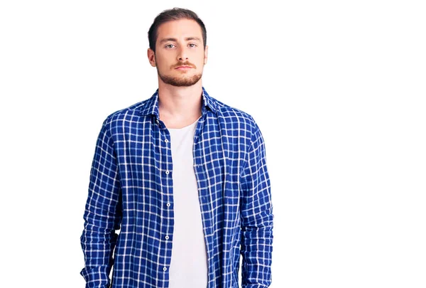 Sıradan kıyafetler giyen yakışıklı beyaz bir adam. Yüzünde ciddi bir ifadeyle rahatlamış. Basit ve doğal bir şekilde kameraya bakıyorsun.. 