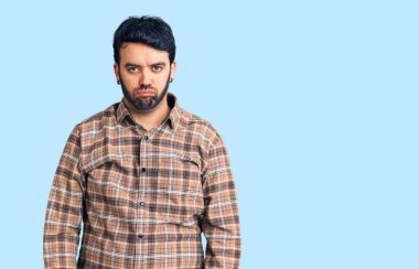 Günlük giysiler giyen genç İspanyol bir adam depresyonda ve sıkıntıdan endişe ediyor, kızgın ve korkmuş bir şekilde ağlıyor. hüzünlü ifade. 