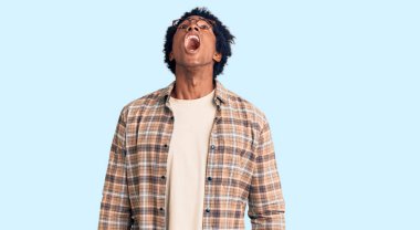 Afro saçlı, sıradan giyinmiş, gözlüklü kızgın, sinirli ve öfkeli sinirli sinirli sinirli sinirli ve öfkeyle bağıran yakışıklı Afro-Amerikalı bir adam. öfke ve agresif konsept. 