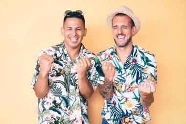 Yaz şapkası ve Hawaii gömleği giyen iki genç eşcinsel erkek, kolları havada ve gözleri kapalı olarak başarıları için şaşkınlığa ve hayrete düştüler. Kazanan konsept. 