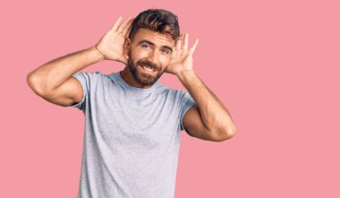 Gündelik giysiler giyen genç İspanyol adam iki elini de kulak hareketlerini duymaya çalışıyor. Dedikoduya meraklı. İşitme sorunu, sağır 