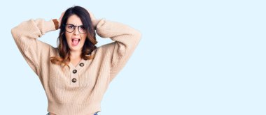 Güzel, genç, esmer bir kadın. Günlük kıyafetler ve gözlük takıyor. Çılgına dönmüş ve elleri başının üstünde korkmuş. 