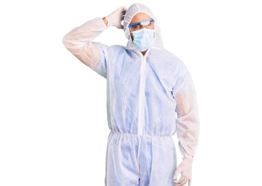 Doktor korumalı koronavirüs üniforması giyen genç İspanyol adam tıbbi maske ve şaşkınlık içinde soru soruyor. Şüpheyle kararsız, kafa kafaya düşünerek. Düşünceli kavram. 