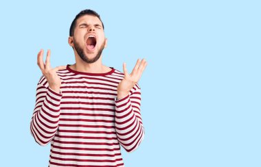 Çizgili süveter giyen genç, çılgın ve çılgın başarıyı kutlayan, kollarını kaldırmış, gözlerini kapatmış heyecanlı çığlıklar atan yakışıklı bir adam. Kazanan konsept 