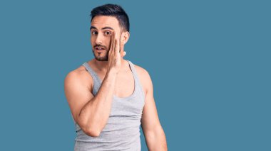 Mayolu ve kolsuz tişörtlü genç adam gizli dedikodular anlatıyor, kötü niyetli konuşmalar fısıldıyor. 