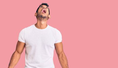 Gündelik kıyafetler giyen genç latin adam kızgın ve kızgın bağırıyor sinirli ve öfkeli, öfkeyle bağırıyor. öfke ve agresif konsept. 