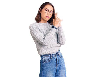 Genç, güzel Çinli kız gündelik giysiler giyip elinde sembolik bir silahla el hareketleriyle cinayet silahlarıyla ateş ediyor ve kızgın bir yüz takınıyor. 