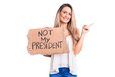 Genç, güzel, sarışın bir kadın, elinde benim başbakanımın karton pankartı değil, mutlu bir şekilde gülümsüyor. 