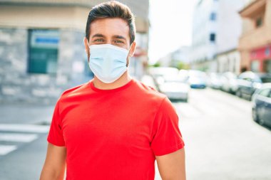 Kentin caddesinde duran yakışıklı İspanyol koruma maskesi takan yakışıklı adam..