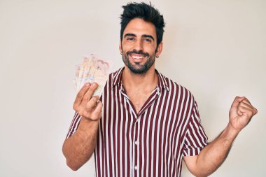 Birleşik Krallık 'ta sakallı yakışıklı İspanyol bir adam gururla bağırıyor, zaferi ve başarıyı kutluyor. 