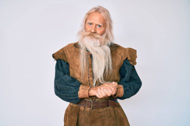 Gri saçlı, uzun sakallı, Viking kostümü giyen, ellerini birleştirip gülümseyen, gevşemiş ve neşeli parmaklarını çapraz yapan yaşlı bir ihtiyar. Başarı ve iyimserlik 