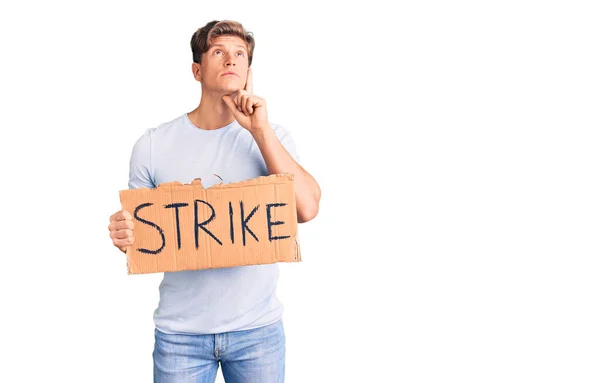 Young Handsome Man Holding Strike Banner Cardboard Serious Face Thinking — Stock Photo, Image
