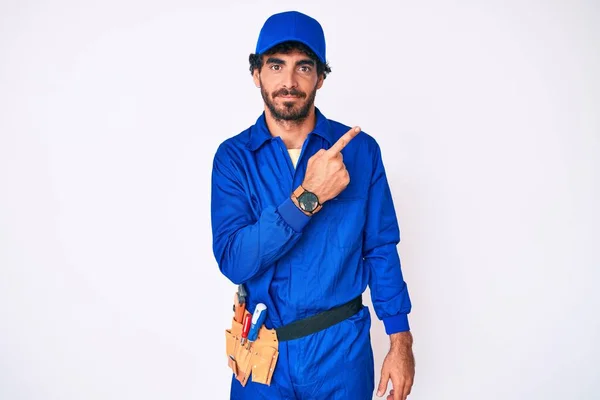 Bonito Jovem Com Cabelo Encaracolado Urso Weaing Handyman Uniforme Apontando — Fotografia de Stock