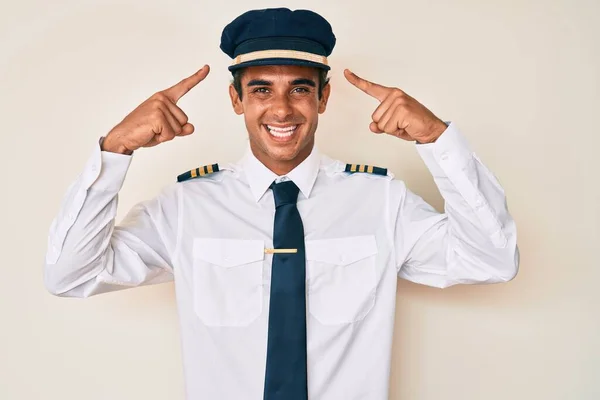 Jonge Spaanse Man Draagt Vliegtuig Piloot Uniform Glimlachend Wijzend Naar — Stockfoto