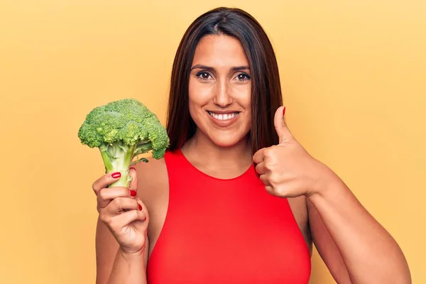 Jovem Bela Morena Segurando Brócolis Sorrindo Feliz Positivo Polegar Para — Fotografia de Stock