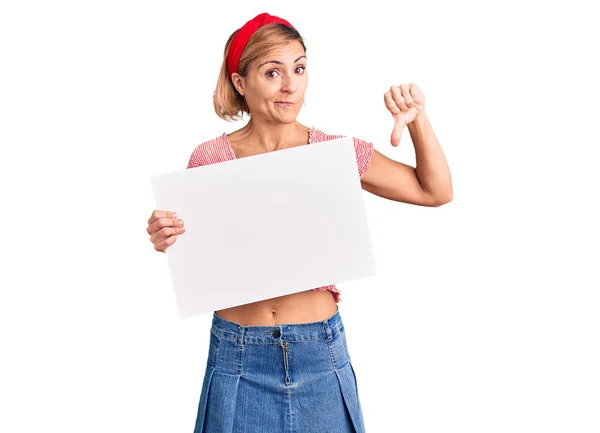 Mujer Rubia Joven Sosteniendo Banner Vacío Blanco Con Cara Enojada —  Fotos de Stock