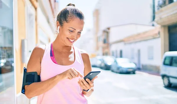 Medelålders Idrottskvinna Ler Glad Med Smartphone Stan — Stockfoto