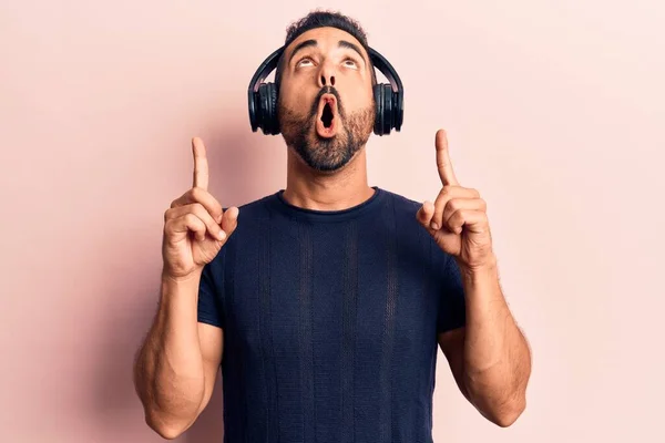 Νέοι Ισπανόφωνοι Ακούγοντας Μουσική Χρησιμοποιώντας Ακουστικά Κατάπληκτος Και Έκπληκτος Κοιτάζοντας — Φωτογραφία Αρχείου