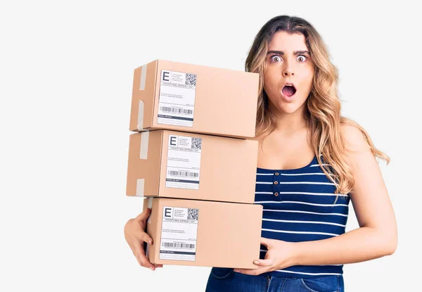 Young Caucasian Woman Holding Delivery Package Scared Amazed Open Mouth — Stock Photo, Image