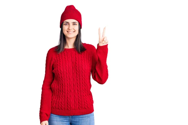 스웨터를 모자를 아름다운 소녀가 자신감 행복하게 웃으면서 손가락 고개를 있습니다 — 스톡 사진