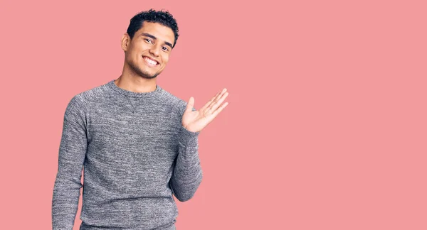 Joven Guapo Hispano Usando Suéter Casual Sonriendo Alegre Presentando Señalando —  Fotos de Stock