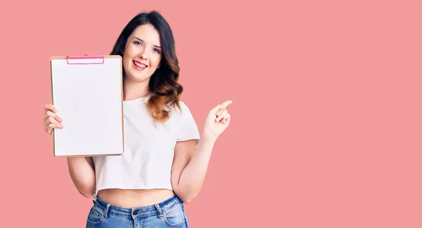 Mulher Morena Bonita Segurando Prancheta Com Espaço Branco Sorrindo Feliz — Fotografia de Stock