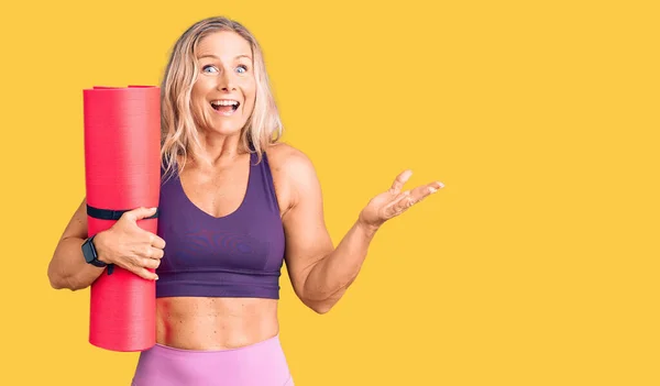 Middelbare Leeftijd Fit Blonde Vrouw Houden Yoga Mat Vieren Overwinning — Stockfoto
