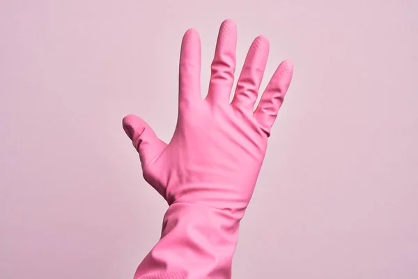 带着清洁手套的高加索年轻人的手在孤立的粉色背景上数着5个手指 — 图库照片