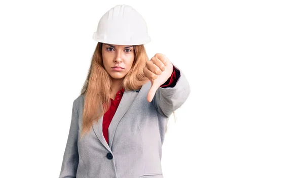 漂亮的年轻女子戴着建筑师的硬礼帽 看上去很不高兴 很生气 表现出排斥和负面的手势 不好的表达方式 — 图库照片