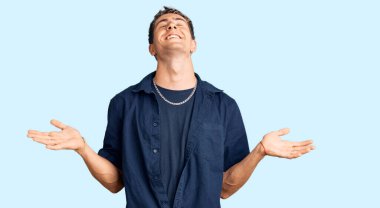 Gündelik kıyafetler giyen genç, çılgın ve çılgın başarıyı kutlayan kollarını kaldırmış, gözlerini kapatmış heyecanlı çığlıklar atan yakışıklı bir adam. Kazanan konsept 