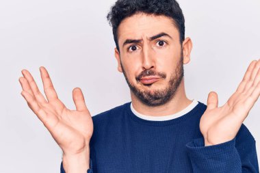 Gündelik kıyafetler giyen genç İspanyol adam habersiz ve kolları açık, hiçbir fikri ve şüpheli bir yüzü var.. 