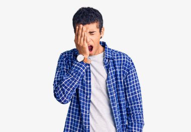 Genç Afro-Amerikan bir adam günlük kıyafetler giyiyor. Yarı yüzünü, göz ve ağzını eliyle kapatmaktan yorulmuş. Yüzüm acıyor.. 