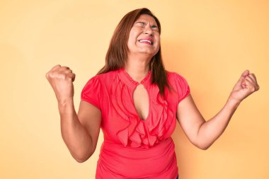 Orta yaşlı esmer, İspanyol bir kadın. Yazlık elbise giyiyor. Çok mutlu ve heyecanlı. kutlama konsepti. 