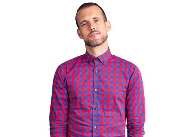 Gündelik kıyafetler giyen genç yakışıklı adam yüzünde ciddi bir ifadeyle rahatlamış. Basit ve doğal bir şekilde kameraya bakıyorsun.. 