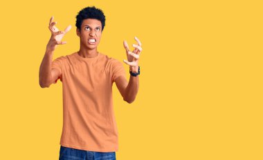 Genç, Afro-Amerikan bir adam günlük giysiler içinde öfkeyle bağırıyor, elleri boğmaya çalışıyor, deli gibi bağırıyor. 