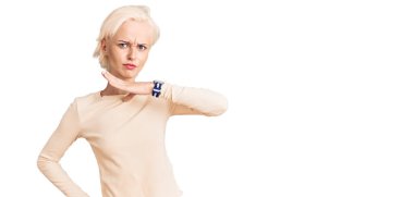 Sıradan kıyafetler giyen genç sarışın kadın bıçak niyetine boğazını kesiyor, saldırganlığı şiddetli bir şiddetle tehdit ediyor. 