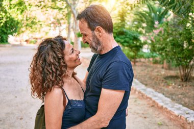 Ormanda mutlu gülümseyen sıradan kıyafetler giyen orta yaşlı bir çift.