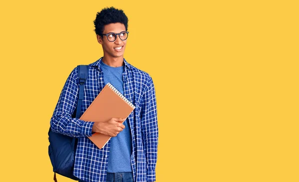 Joven Hombre Afroamericano Con Mochila Estudiante Sosteniendo Libro Sonriendo Mirando —  Fotos de Stock