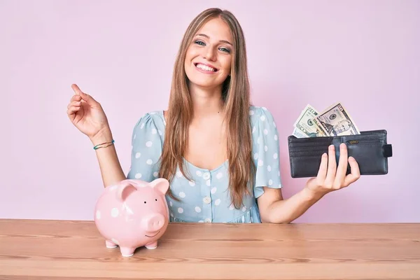 Jong Blond Meisje Houden Portemonnee Met Dollars Spaarvarken Bank Zitten — Stockfoto