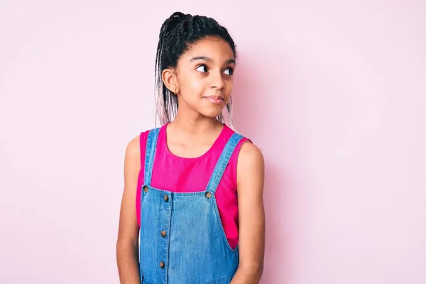 若いですアフリカ系アメリカ人の女の子子供とともにBraids身に着けていますカジュアルな服上のピンクの背景笑顔側を見て離れて考え方 — ストック写真