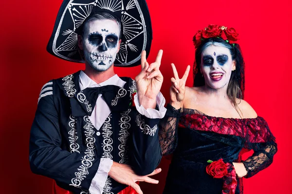 Kırmızı Üzerine Meksika Kostümlü Genç Bir Çift Kameraya Bakıp Gülümsüyor — Stok fotoğraf